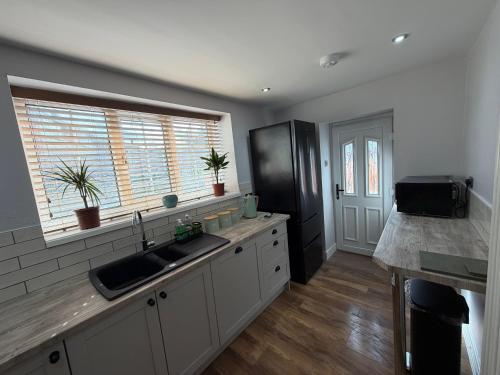 a kitchen with a sink and a window at 3 bed detatched cottage with onsite parking in Rotherham