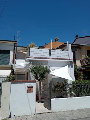 a white house with an open door with an umbrella at Da' Mi ' Nonni in Viareggio