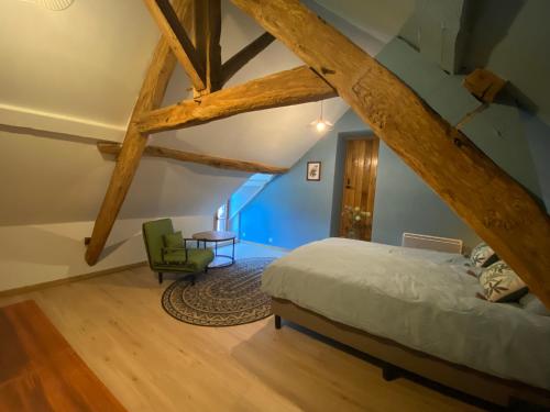 a bedroom with a bed and a green chair at Mon Repos, onze sfeervolle gîte in Haims