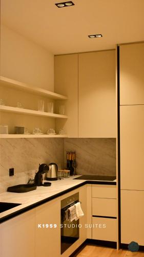 a kitchen with white cabinets and a stove at K1959 Studio Suites in Peje