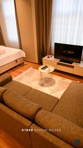 a living room with a couch and a flat screen tv at K1959 Studio Suites in Peje