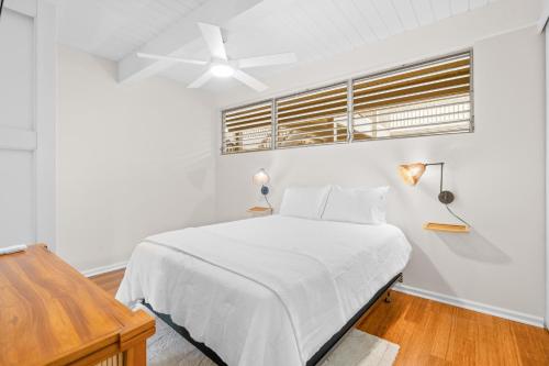 a white bedroom with a bed and a ceiling fan at Kona Mansions#208 in Kailua-Kona