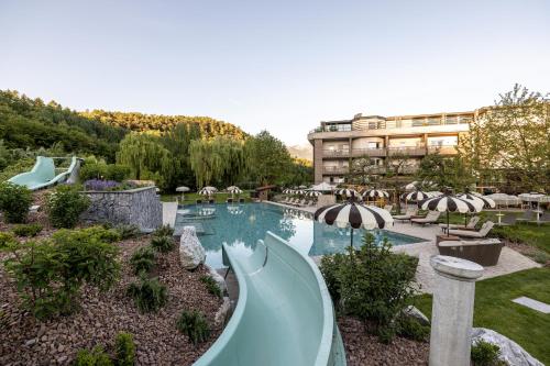 a pool with a water slide in a resort at Gartenhotel Moser in Appiano sulla Strada del Vino