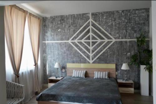 a bedroom with a large bed and a wall at Хотел Брио Велинград in Velingrad