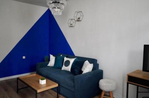 a blue couch in a living room with a blue and white wall at Хотел Брио Велинград in Velingrad