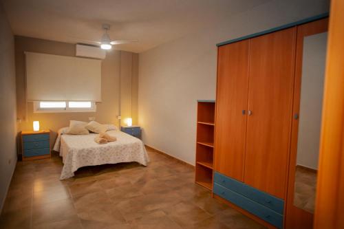 a bedroom with a bed and a wooden cabinet at Casa La Fuente in Chella