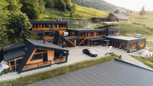 a house with a car parked in front of it at Panoramic Residence in Borşa