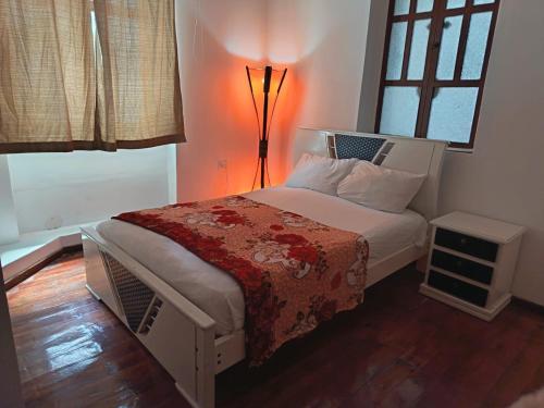a bedroom with a bed with a lamp on it at Guesthouse Nelson L in Quito