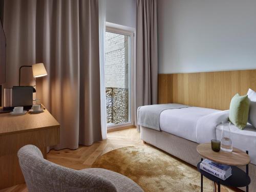a hotel room with a bed and a window at DIALOGUE Boutique Hotel in Brno