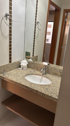 a bathroom counter with a sink and a mirror at Boulevard Park in Caldas Novas