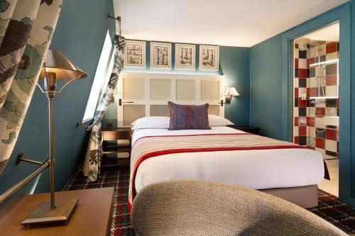 una camera d'albergo con letto e sedia di Les Tournelles a Parigi