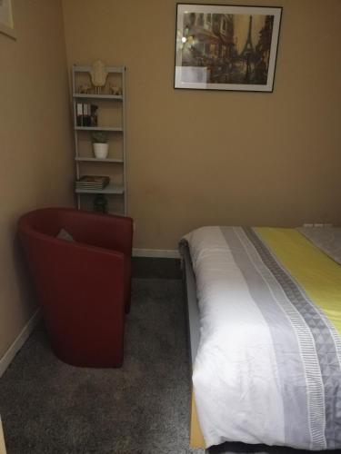 a bedroom with a bed and a chair at Rose dor in Plombières-lès-Dijon