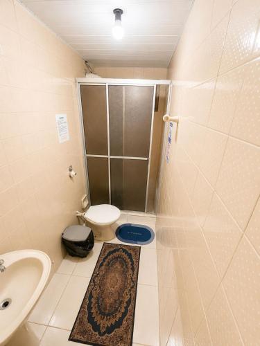 a small bathroom with a toilet and a sink at Pensão Meg in São José