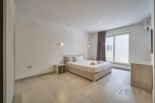 a bedroom with a bed and a large window at Beautiful View, 3 Bedroom Spacious Apartment in Tal-Pietà