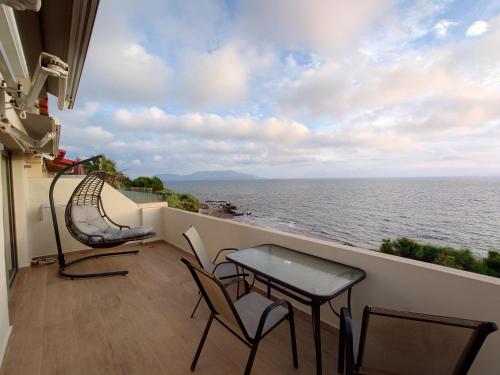 a balcony with chairs and a table and a view of the ocean at Ionian Moon 1 in Preveza