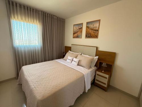 a bedroom with a white bed and a window at Vista Panorâmica • Premium in Palmas