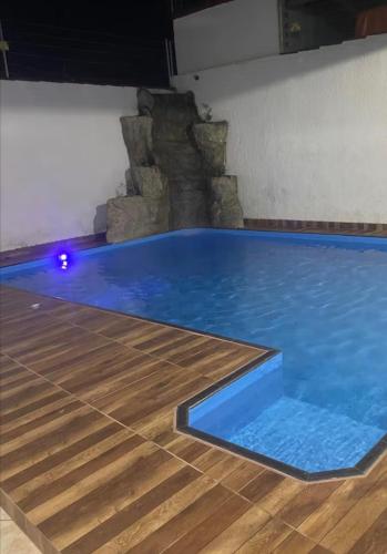 a large blue swimming pool with a wooden floor at Sua casa longe de casa in Anápolis