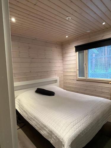 a bedroom with a white bed in a room with a window at Kurjenpesä in Kalajoki
