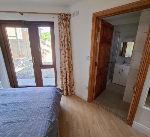 a bedroom with a bed and a sliding glass door at Sea Loft in Shankill
