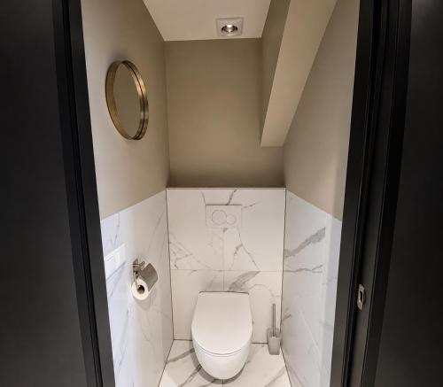 a small bathroom with a toilet and a mirror at Family holiday home by beach and forest in Dirkshorn