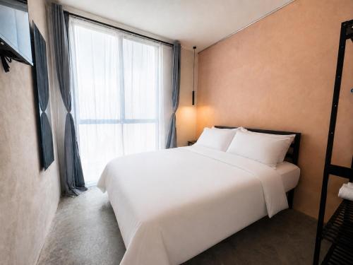 a white bed in a room with a large window at Casa Rosa in Aguascalientes