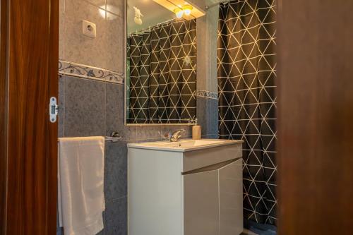 a bathroom with a sink and a mirror at Luz's Retreat Apartment in Ponta Delgada