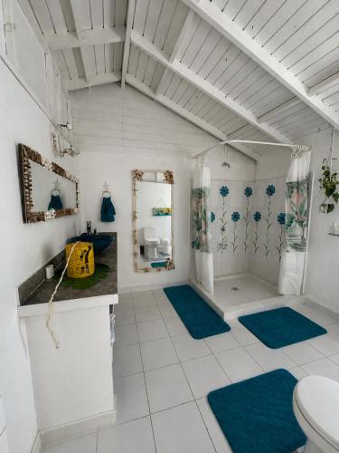 a bathroom with a toilet and blue rugs at Siloe Cove Hospedaje Campestre in San Andrés