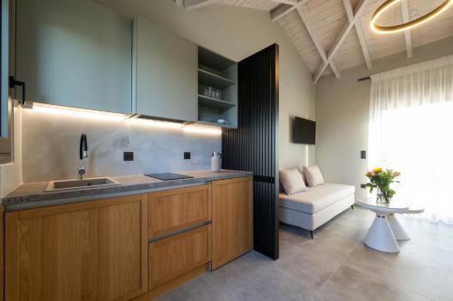 eine Küche mit Spüle und eine Couch in einem Zimmer in der Unterkunft Koroni Poolside Suites in Koroni