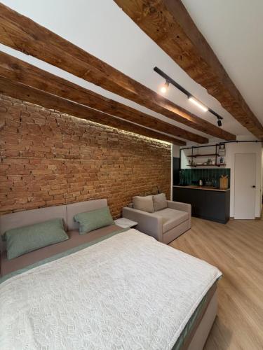 a bedroom with a bed and a brick wall at VIP apartment 40 in Lviv