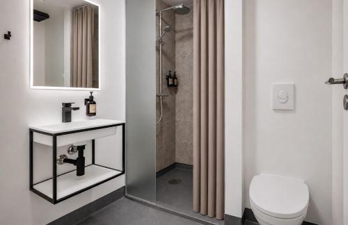 ein Badezimmer mit Toilette, Waschbecken und Dusche in der Unterkunft Hotel Kongens Ege in Randers