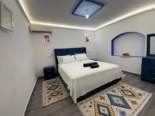 a bedroom with a large bed and a rug at Casa Inass blue in Chefchaouen
