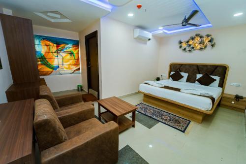 a living room with a bed and a couch at Ravila Grand Hotel in Lingampalli