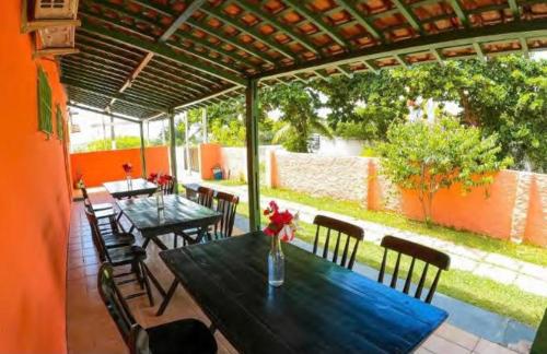 a dining area with tables and chairs and a patio at Suites Mar a Vista in Porto De Galinhas