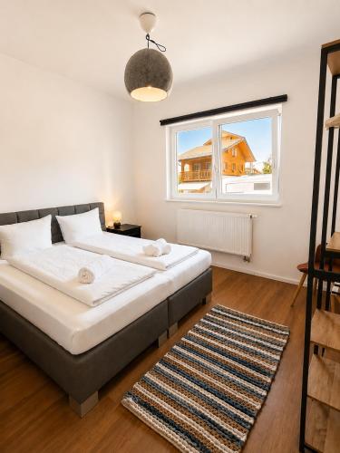 a bedroom with a bed and a window and a rug at Allgäu Ferienhaus 5 Apartments mit Sauna,Balkon, Garten und Privatparkplatz in Blaichach
