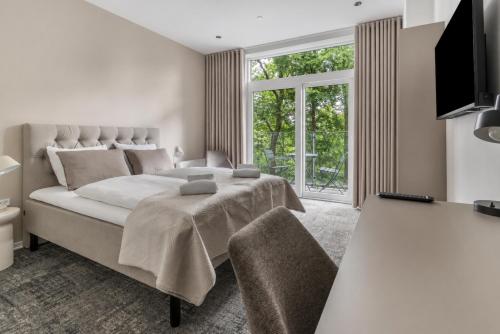 ein Schlafzimmer mit einem großen Bett und einem großen Fenster in der Unterkunft Hotel Kongens Ege in Randers