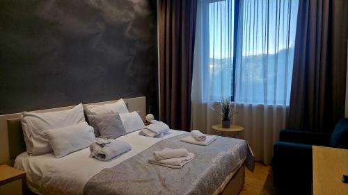 a bedroom with a bed with towels and a window at RELAX-zepter in Vrnjačka Banja