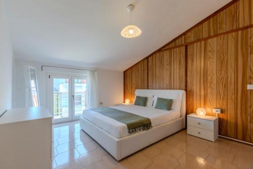 a bedroom with a large white bed and wooden walls at Family friendly apartment in Giba Center in Giba