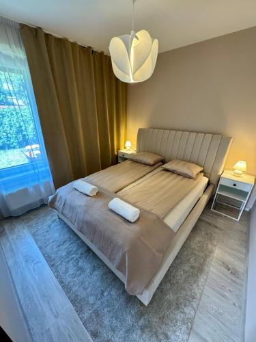 a bedroom with a large bed with two towels on it at Ditta Home in Nyíregyháza