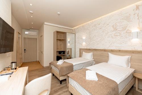 a hotel room with two beds and a map on the wall at Leomare in Odesa