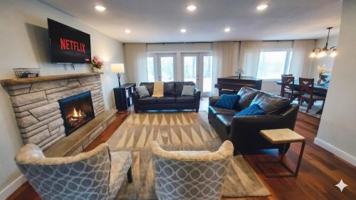 a living room with a couch and a fireplace at Stunning Ranch in the woods in Berrien Springs