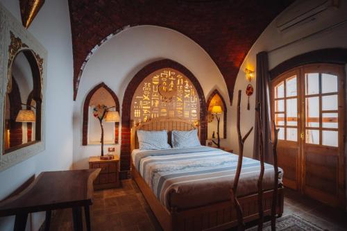 a bedroom with a large bed in a arched room at Villa Kemet in Jazīrat al ‘Awwāmīyah