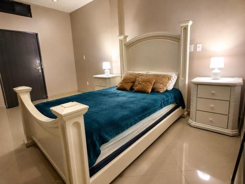 a bedroom with a large bed with a blue blanket at Casa Di Manuelito in Monterrey