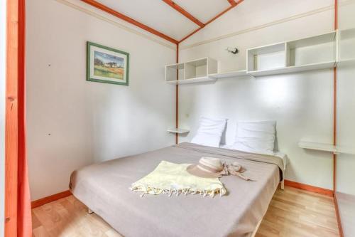 a small bedroom with a bed with a hat on it at Chalet La Caz'à Joooh in Rivières