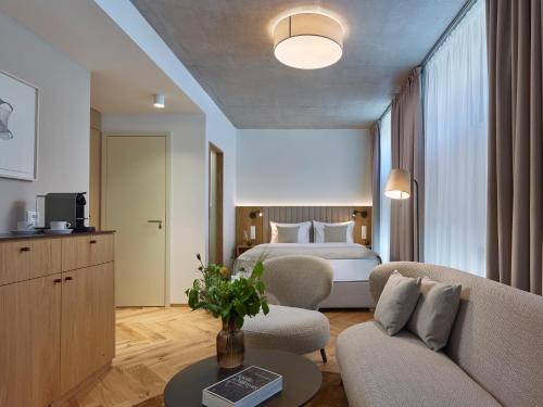 a hotel room with a bed and a couch at DIALOGUE Boutique Hotel in Brno