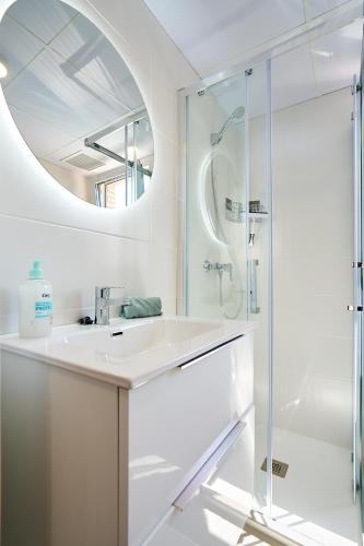 a white bathroom with a sink and a mirror at Sun&Fun Villa in Vinarós