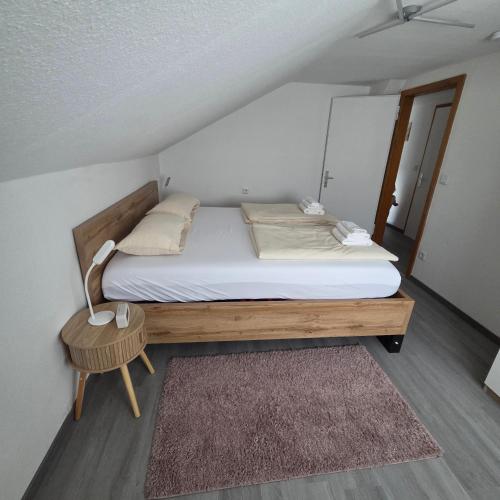a small bedroom with a bed and a table at Im Buchenweg in Großheubach