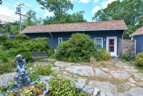 a blue house with a bench in front of it at Granite Cottage in Rockport
