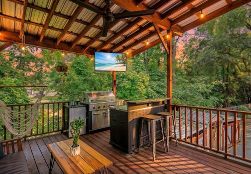 a screened in deck with a grill and a television at Island Retreat - Great for Large Groups in Charleston