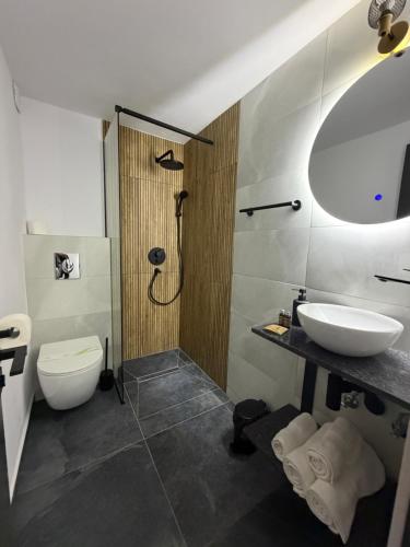 a bathroom with a toilet and a sink and a shower at New Venus in Curtea de Argeş