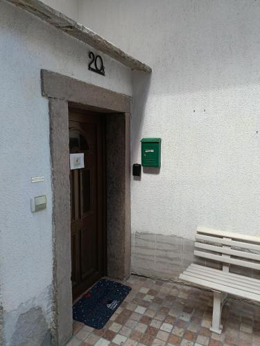 a door to a building with a bench next to it at Casa Fabiola in Longarone